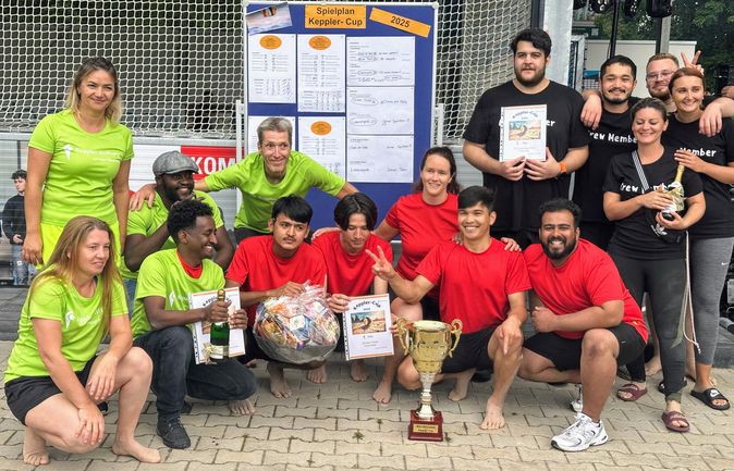 Team mit Wanderpokal und Urkunden vor Spielplan Keppler-Cup